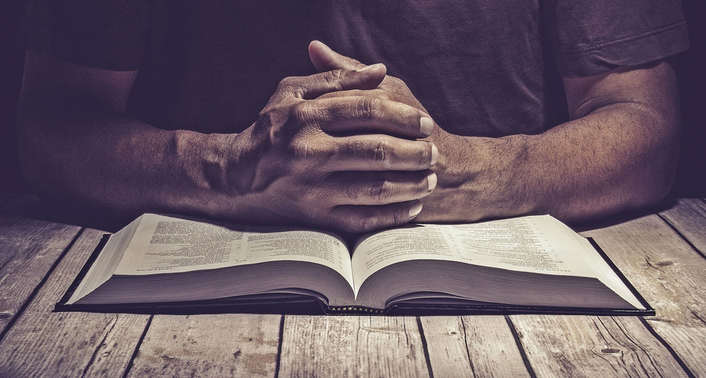 Praying hands with bible